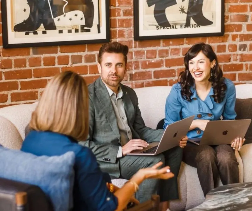 Three Change Craft team members meeting with laptops